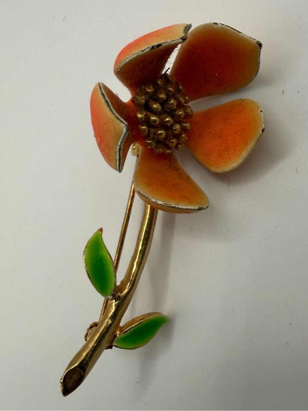 Vintage orange enamel petals and a textured gold-tone center